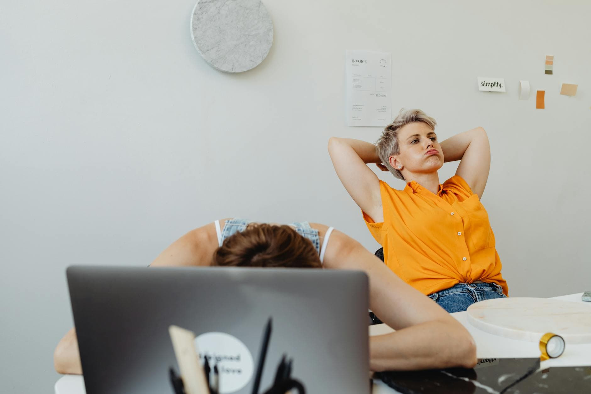 Porównanie ergonomii pracy przy biurku: kobieta z poprawną postawą (wyprostowany kręgosłup, monitor na wysokości wzroku) kontra błędna postawa z tzw. wysuniętą głową i zaokrąglonymi plecami.